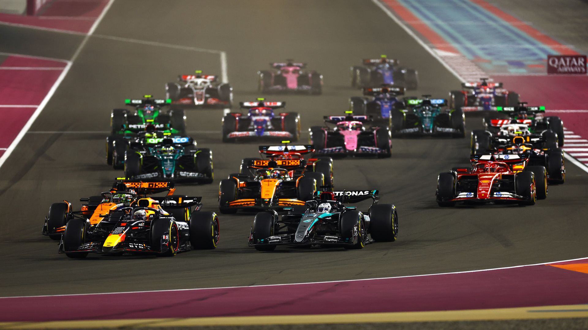 A picture of single seater cars racing at a circuit.